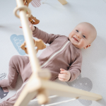 tappe sviluppo neonato - bambino di 6 mesi sdraiato a pancia in su che sorride