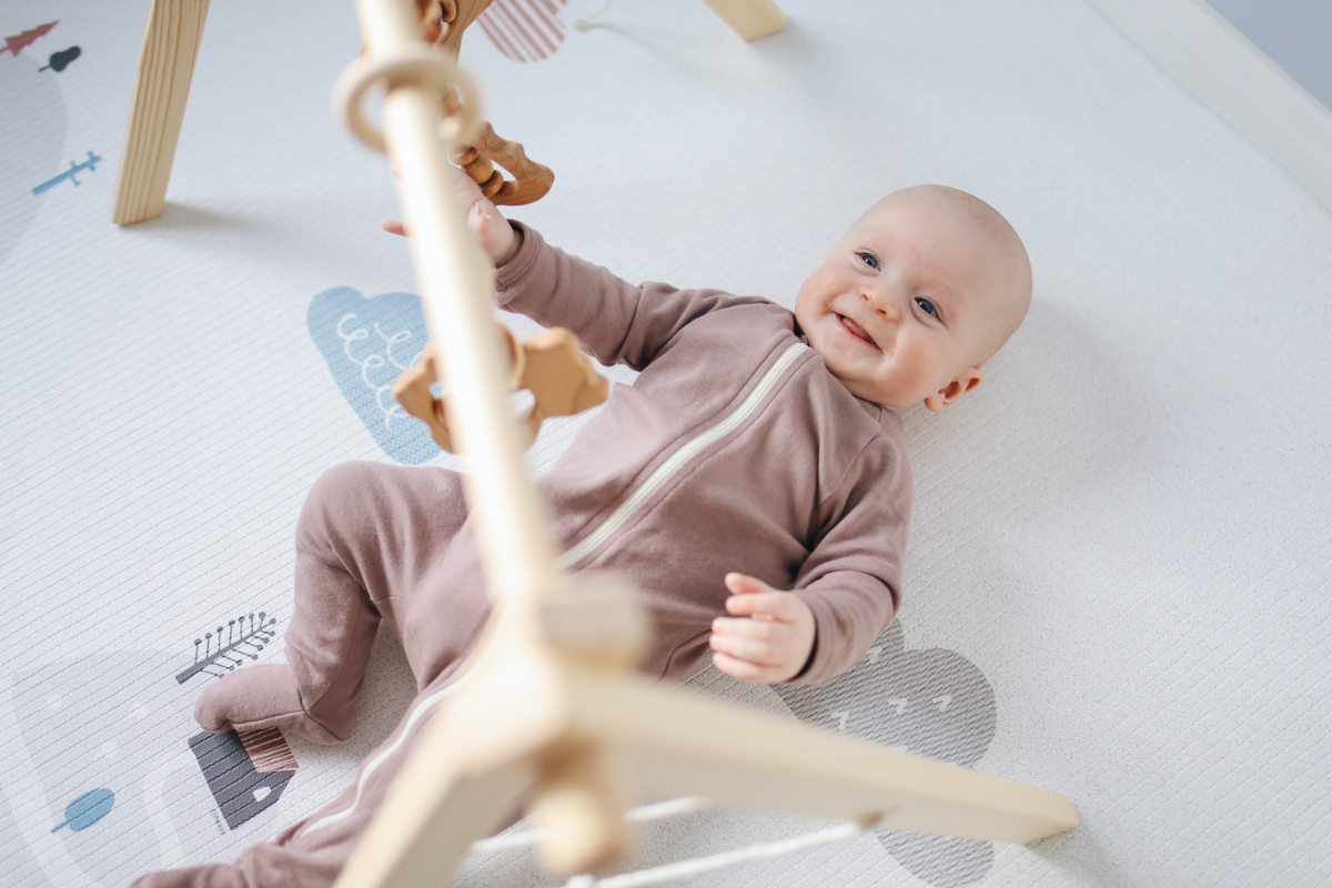 tappe sviluppo neonato - bambino di 6 mesi sdraiato a pancia in su che sorride