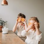 vitamine per difese immunitarie bambini - bambino e bambina che giocano con le arance