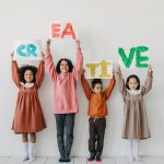 attività creative per bambini da 1 a 6 anni - gruppo di 4 bambini di età diverse con in mano un cartello con scritto "creative"