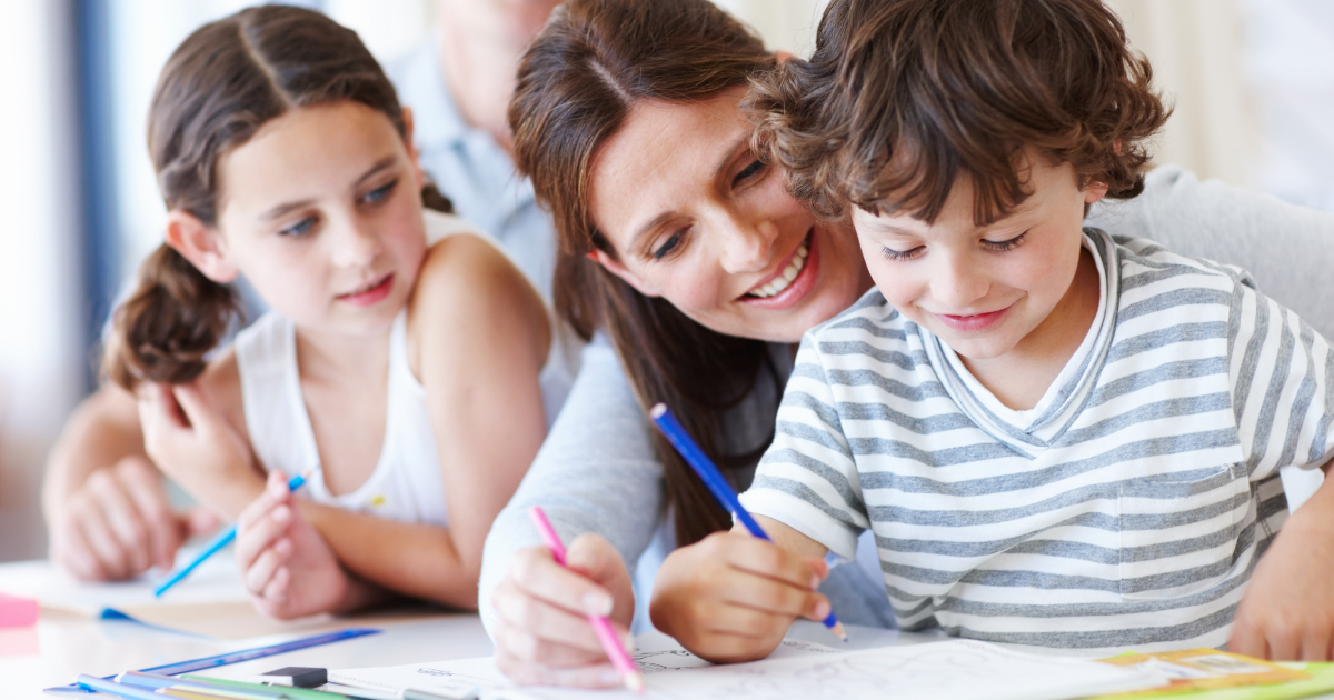 insegnare le regole ai bambini - mamma che aiuta il figlio a scrivere e colorare