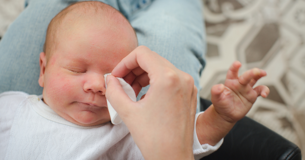 pulizia occhi neonato - neonato ad occhi mentre la mamma gli pulisce l'occhio